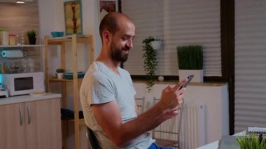 Adam çalışırken telefon edip gülümsüyor.