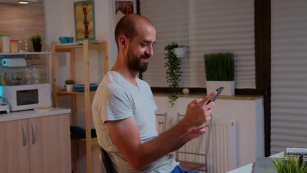 Homme utilisant téléphone et sourire tout en travaillant — Video