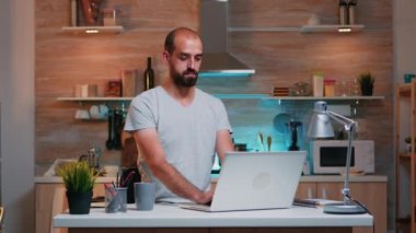 İşadamı evde dizüstü bilgisayar kullanıyor.