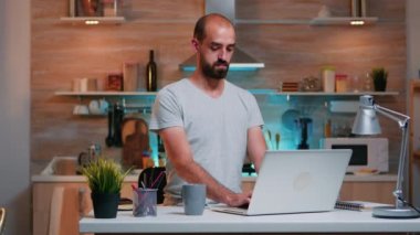 Yorgun adam gece geç saatlere kadar çalışırken esniyor.