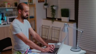 İş adamı geç saatlere kadar çalışırken deftere notlar yazıyor