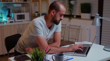 Projeyi bitirmeye çalışan, baş ağrısı olan konsantre bir adam.