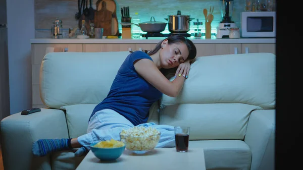 Femme dormant sur un canapé devant la télé — Photo