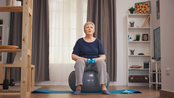 Old retired woman lifting dumbbells — Stock Photo, Image