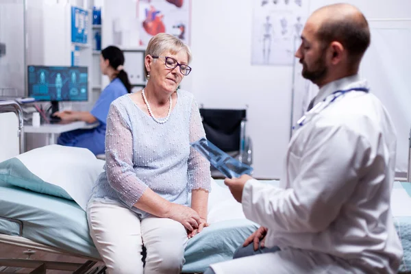 Arzt schaut Patient röntgen — Stockfoto