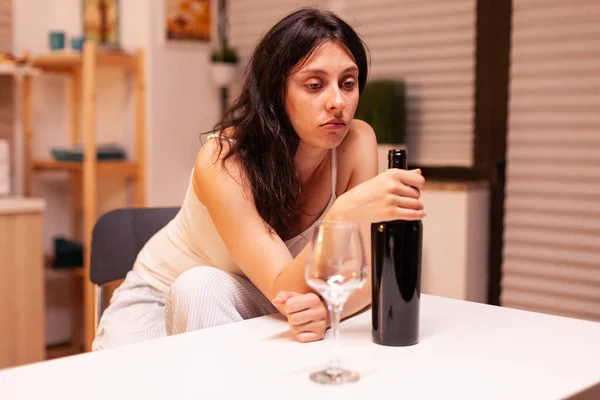 Yalnız kadın elinde bir şişe kırmızı şarap tutuyor.. — Stok fotoğraf