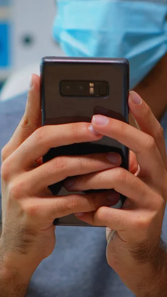 Homem com máscara digitando no telefone — Fotografia de Stock