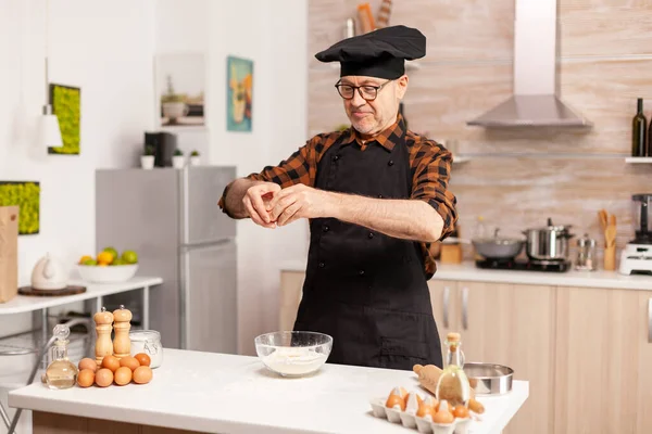 Anciano hombre rompiendo huevos —  Fotos de Stock