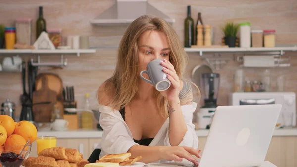Sexy huisvrouw met behulp van laptop — Stockfoto