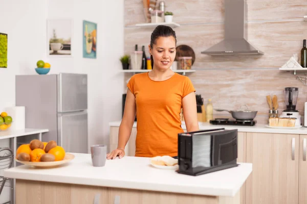 Frau benutzt elektrischen Toaster — Stockfoto