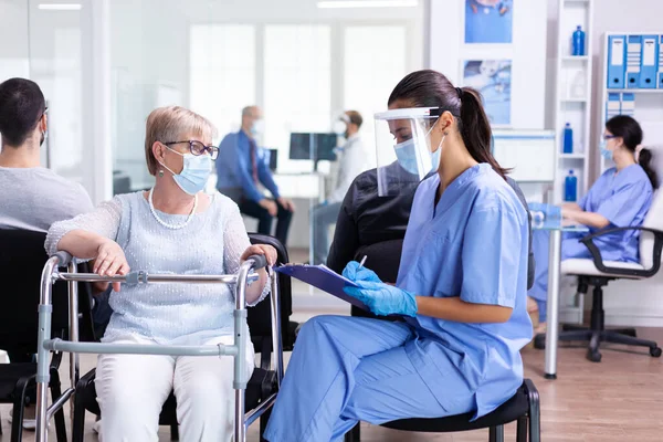 Krankenschwester macht sich Notizen auf Klemmbrett — Stockfoto