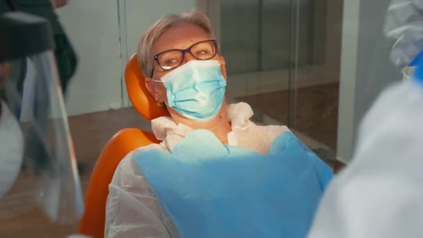 Doktor v ochranném obleku vrtání žena zub během covid -19 — Stock video