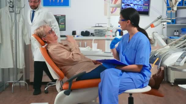 Медсестра делает записи о проблемах с зубами пациентов — стоковое видео