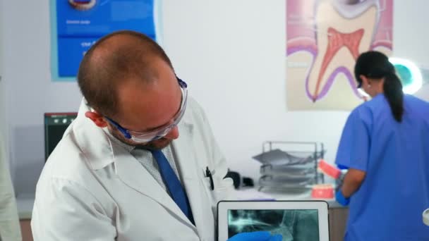 Comprimido con rayos X de mandíbula que se lo muestra al paciente — Vídeos de Stock