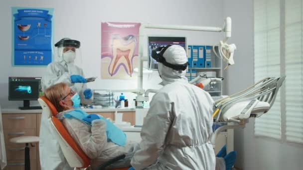 Stomatolog w okładce patrząc na płytkę rentgenowską zębów — Wideo stockowe