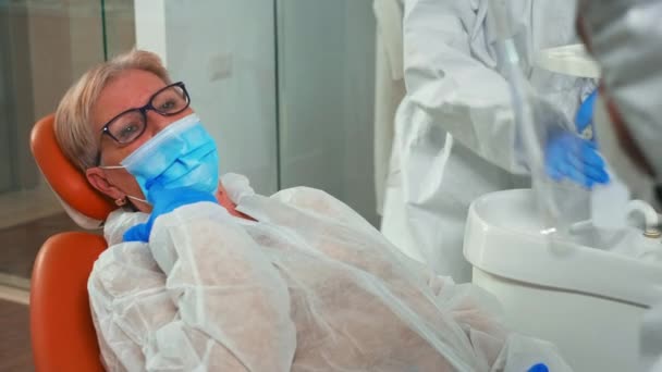 Dentista e donna con maschera parlando di problemi dentali — Video Stock