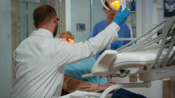 Ortodontista rozsvítí lampu až do vyšetření — Stock video