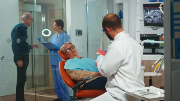 Стоматолог держит гипсовую модель нижней челюсти — стоковое видео
