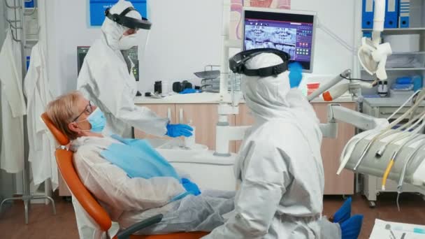 Stomatolog na okładce i pacjent patrząc na cyfrowe prześwietlenie stomatologiczne — Wideo stockowe
