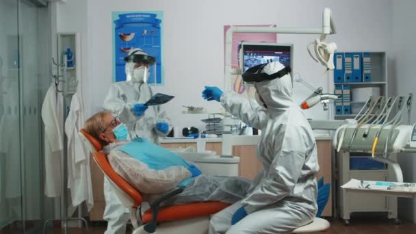 Dentist worker in personal protective kit examining dental x-ray — Stock Video