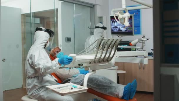 Οδοντίατρος τεχνικός σε coverall προετοιμασία για την οδοντιατρική χειρουργική — Αρχείο Βίντεο