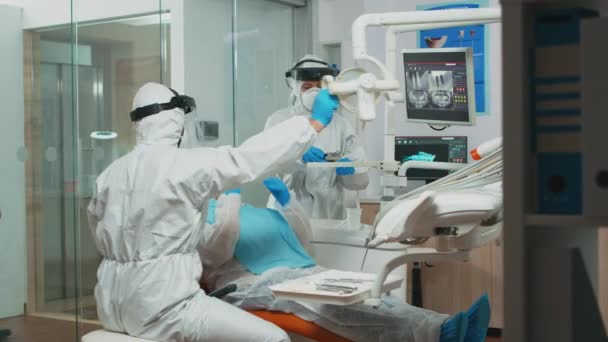 Médico en traje protector usando herramientas dentadas esterilizadas — Vídeos de Stock