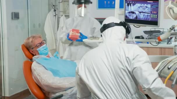 Doctor en bata mostrando higiene dental usando maqueta de esqueleto — Vídeos de Stock