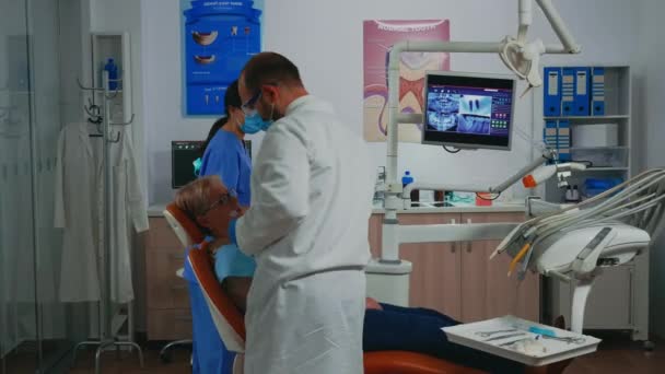 Comprobación de cirujano oral con espejo nuevas coronas dentales — Vídeos de Stock