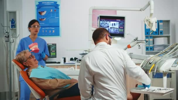 Stomatolog vysvětlující dentální hygienu pomocí zubní kostry — Stock video
