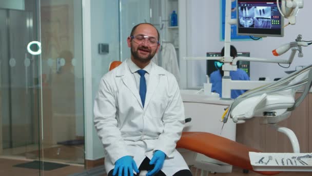 Zahnarzt blickt in Kamera im Gespräch mit Patienten — Stockvideo