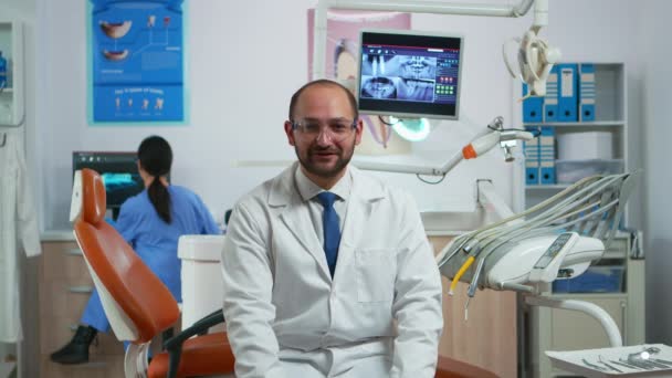 Hombre estomatólogo hablando en cámara de vídeo — Vídeos de Stock