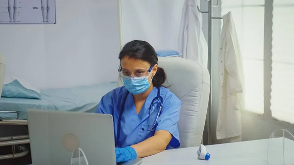 의료 장갑을 끼고 노트북으로 타자하는 간호사 — 스톡 사진