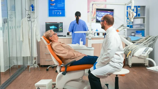 Assistente nella preparazione del paziente all'intervento dentale — Foto Stock