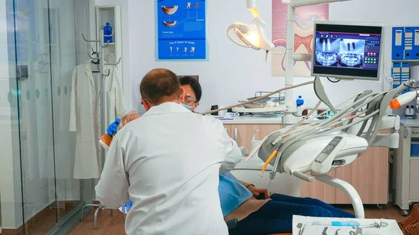 Chirurgo orale che esegue un intervento chirurgico installando impianto — Foto Stock