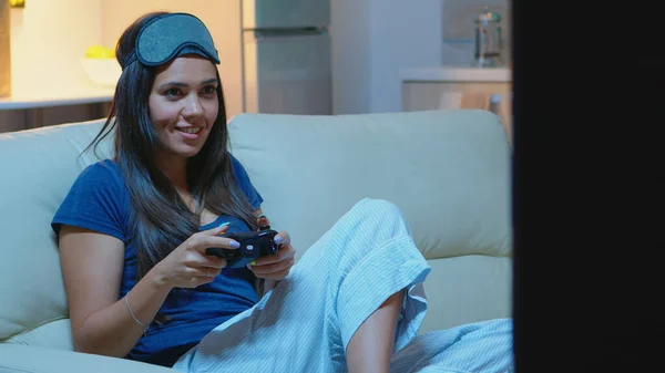 Mujer sentada en un sofá y jugando videojuegos — Foto de Stock