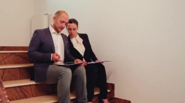 Şirket yöneticisi merdivenlerde ofis yöneticisine danışmanlık yapıyor.