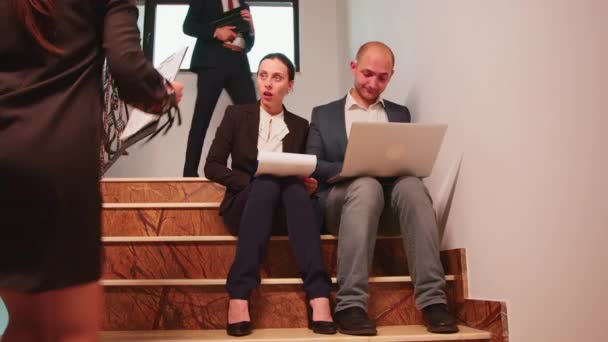 Uomini d'affari che analizzano i rapporti seduti sulle scale — Video Stock