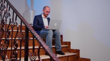 İşadamı üst katta laptopta fazla mesai yapıyor.