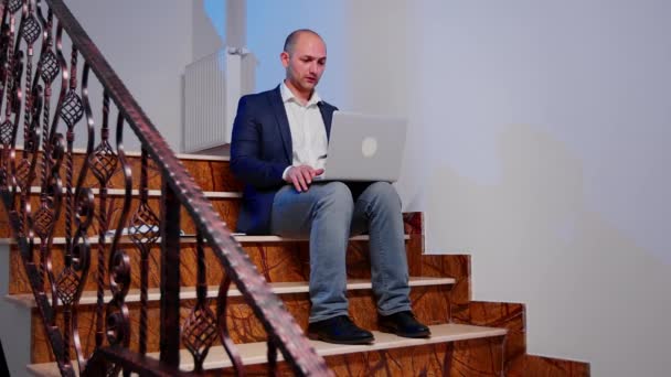 Zestresowany biznesmen zamykający laptopa wzdychając na schodach — Wideo stockowe