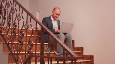 Yorgun girişimci sigara içiyor ve merdivenlerde çalışıyor.