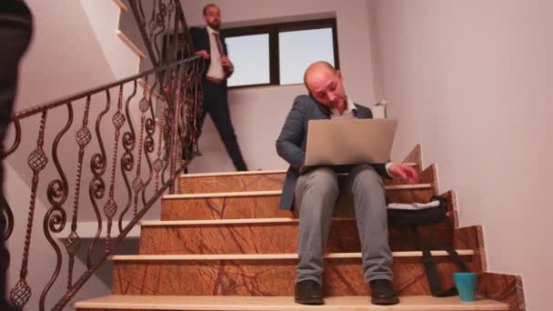 Tippen auf dem Laptop, telefonieren auf der Treppe — Stockvideo