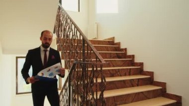 Şirket binasında iş adamları merdivenleri tırmanıyor.