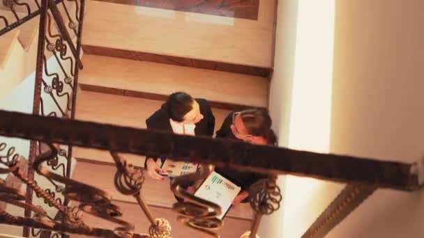 Вид сверху на женщин-коллег, встречающихся на лестнице — стоковое видео