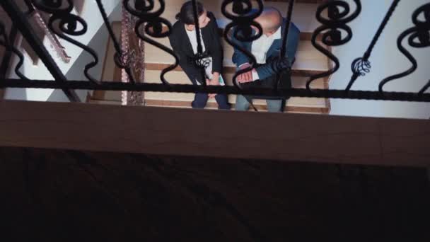 Вид усталой проектной команды, обсуждающей сидение на лестнице — стоковое видео