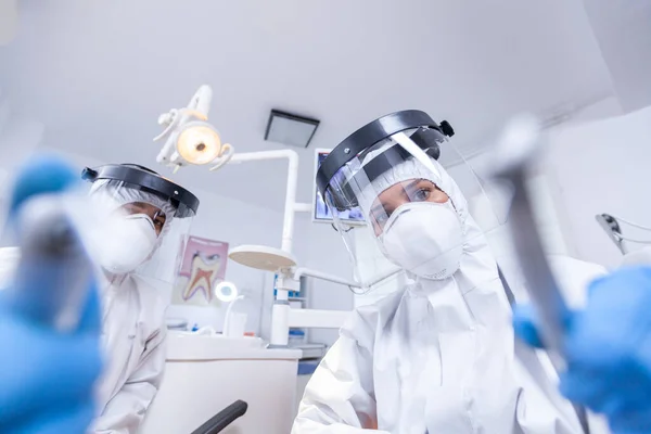 Patiënt gezichtspunt van tandheelkundige team leunend over om te werken in de tandholte — Stockfoto