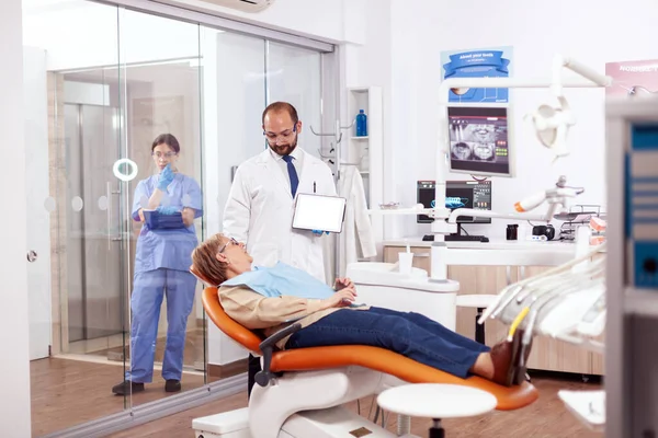 Dentista discutere con la donna anziana nel gabinetto — Foto Stock