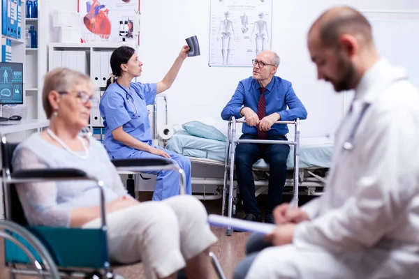 Handikappade äldre man tittar på röntgen — Stockfoto