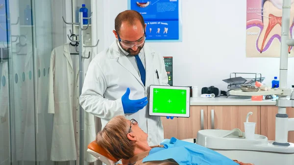 Stomatologist looking at green screen tablet — Stock Photo, Image