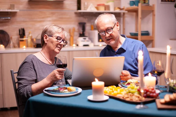 Coppia di anziani utilizzando il computer portatile in cucina — Foto Stock