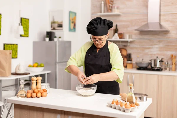 Mujer rompe huevo por encima de harina — Foto de Stock